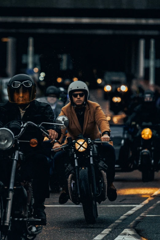 two people are riding on motorcycles at night
