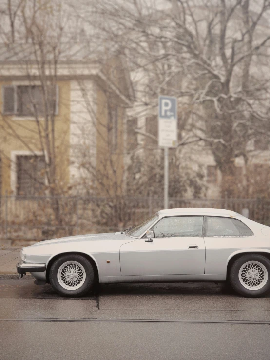 a silver car parked in front of a stop sign