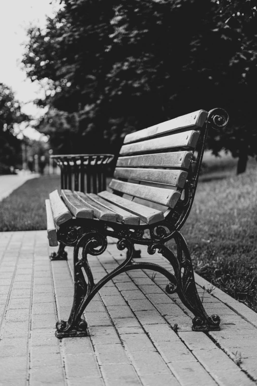 an empty park bench is shown in this black and white po