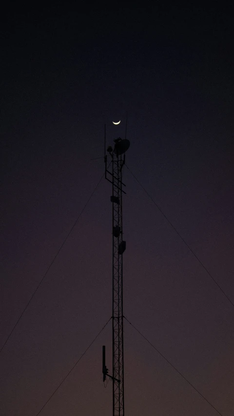 a telephone pole sitting below a dark sky