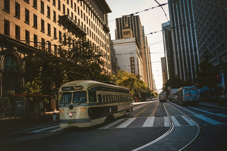 a city bus traveling down a street next to tall buildings