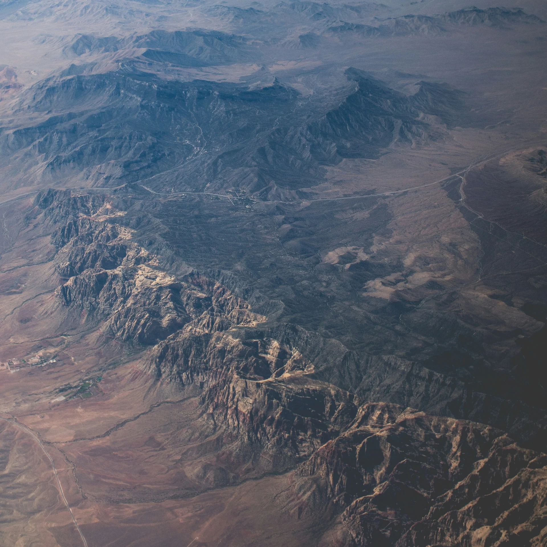 an aerial view of mountains with the airplane flying above