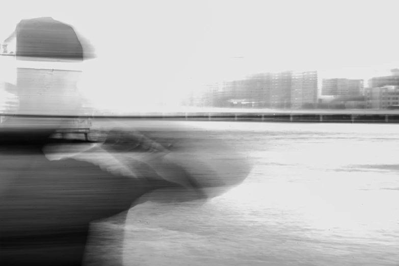 blurry po of a man standing outside near water