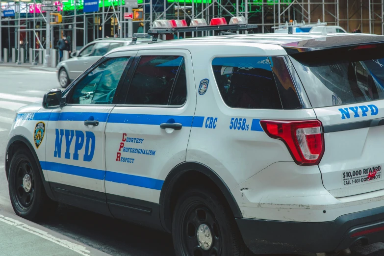 a nypd police car stopped at a red light