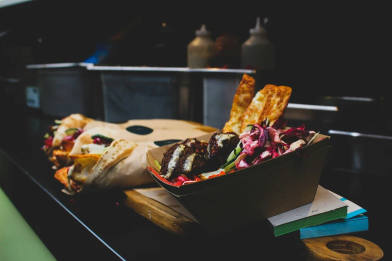 a table holding a box of fries and some sandwiches