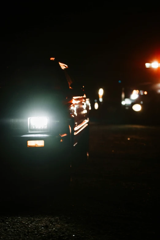 a car is shown in the dark, on a city street