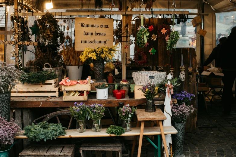 a small store with flowers inside and people in the back