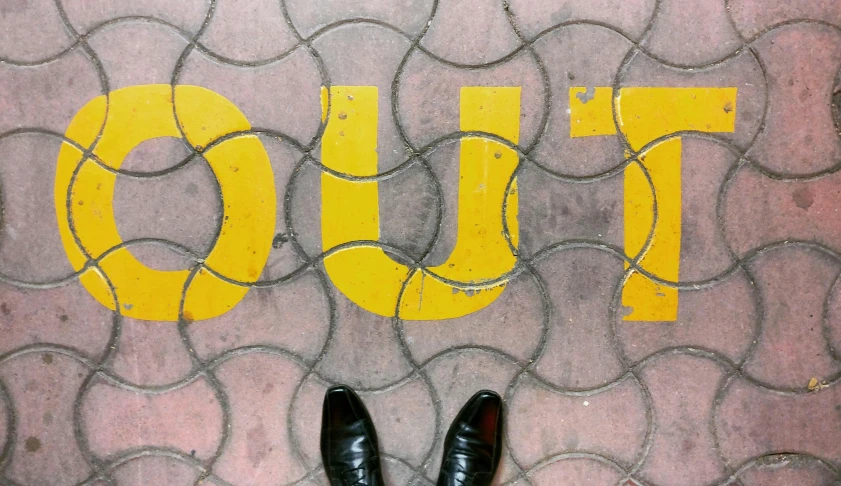 a pair of shoes standing in front of the word to do written on a sidewalk