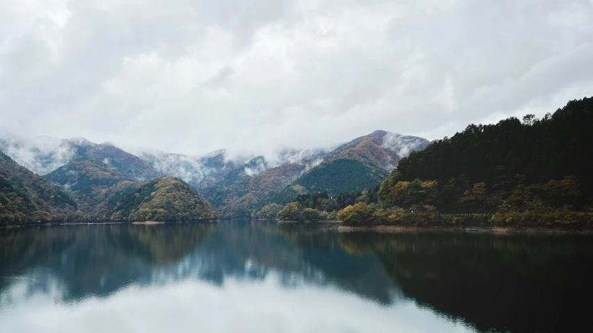 mountains and trees are reflected in a mountain lake