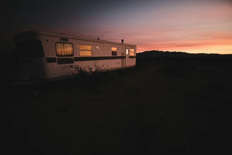 a trailer parked near a hill at dusk