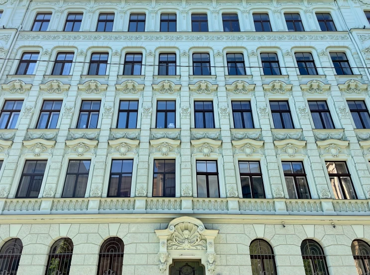 a large building with lots of windows and two birds sitting on the corner