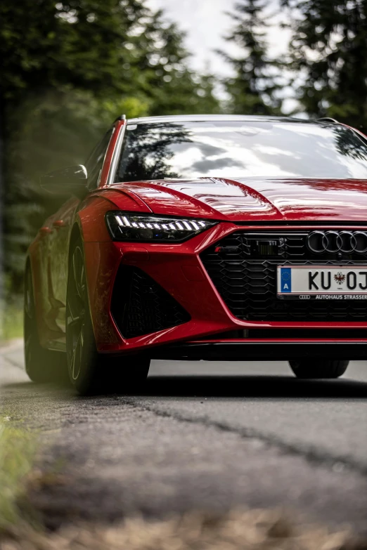 a red sport car driving down a rural road