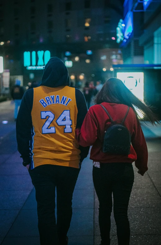 two people walking down a street in a parking lot