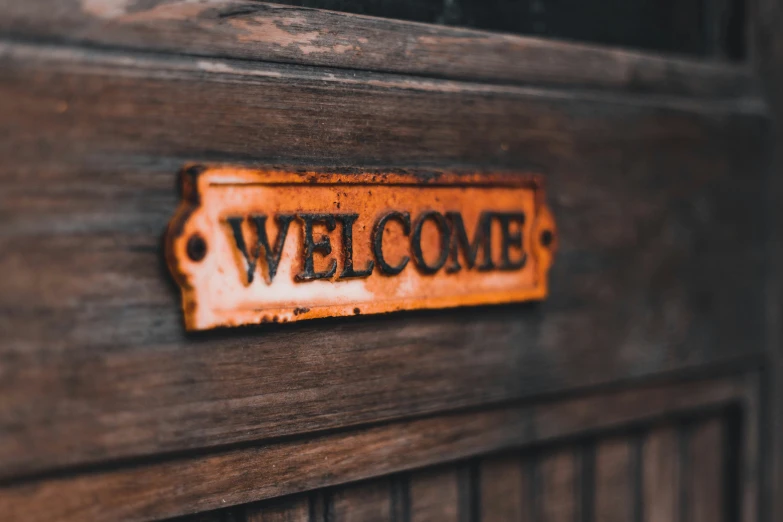 an orange welcome sign is on the side of a door