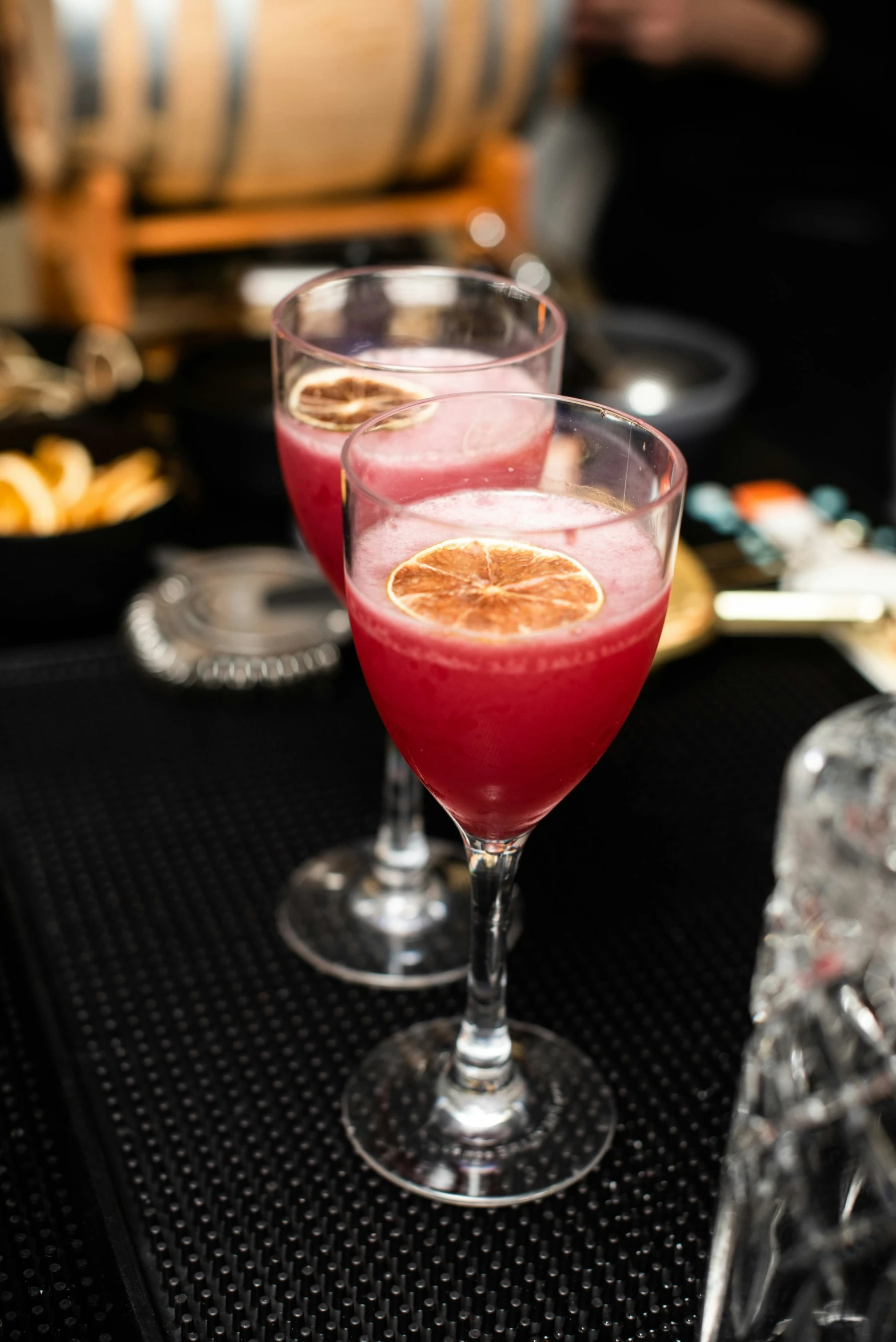 two glasses of fruit like beverages sitting next to each other