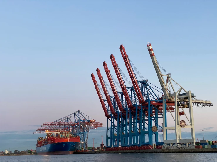 the large boat is docked next to the large crane