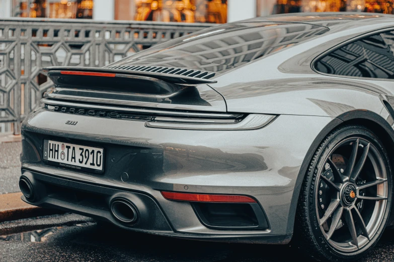 a gray sports car parked near some street signs