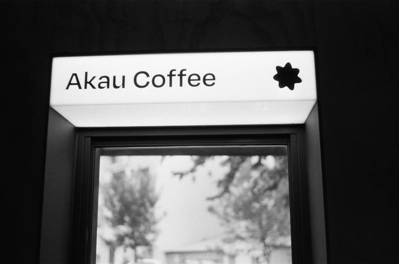 a coffee shop window with a black and white po