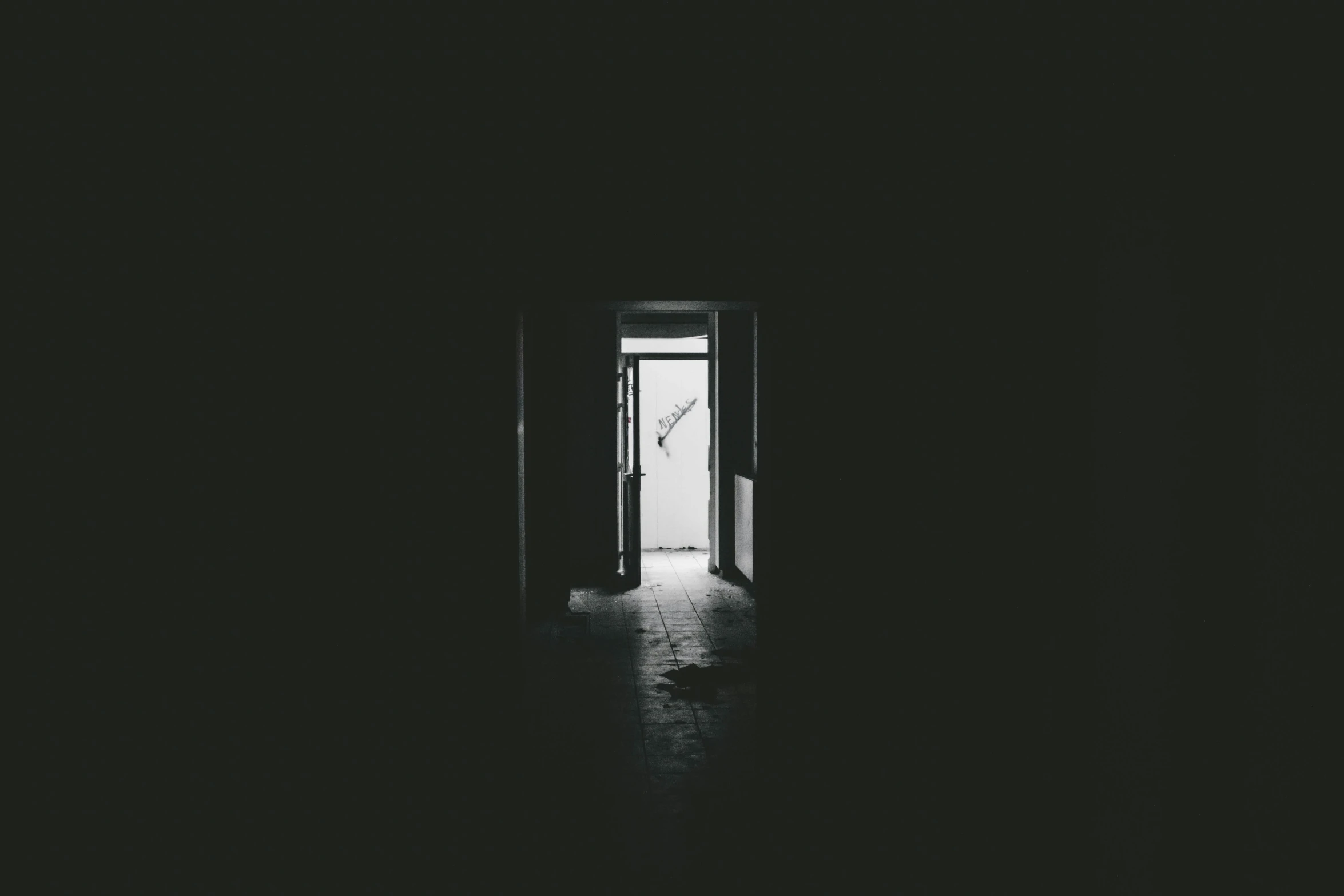 the doorway to a dark room with light at the end