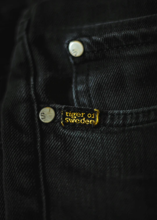 an old pair of black jeans with gold embroidered patching