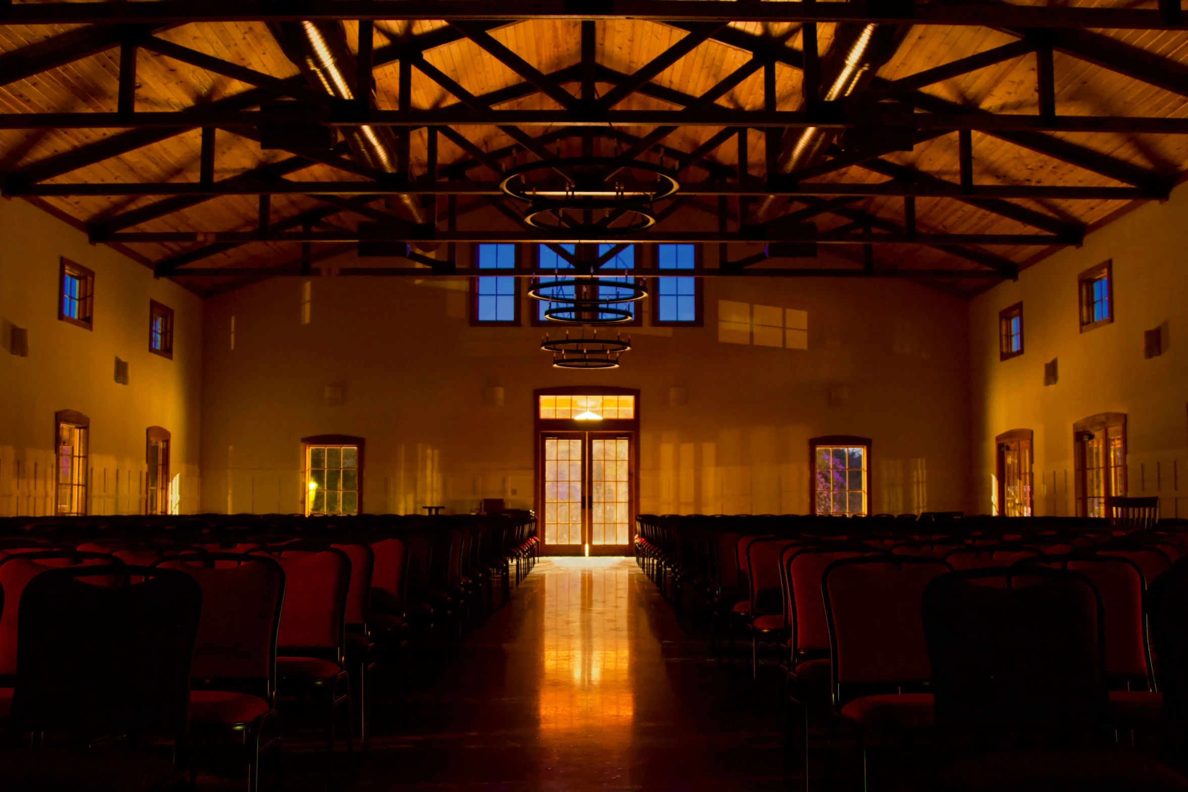 an empty hall with chairs and windows in the building