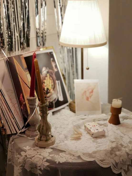 candles are set up on a table next to magazines