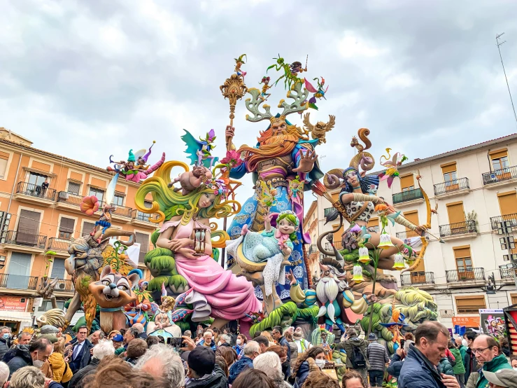 several statues are displayed in the street with many people