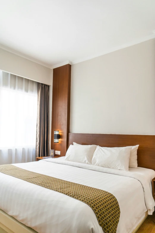 large bed in el room with tall wooden headboard