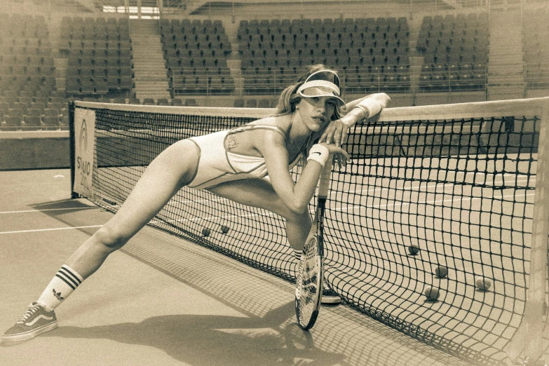 a woman leaning over a tennis net holding her racquet