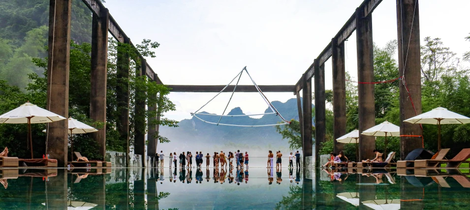 a view of people sitting in the water, with umbrellas over them