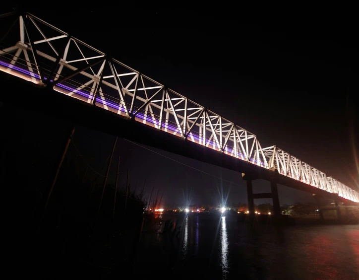 a large bridge spanning over a river in the night