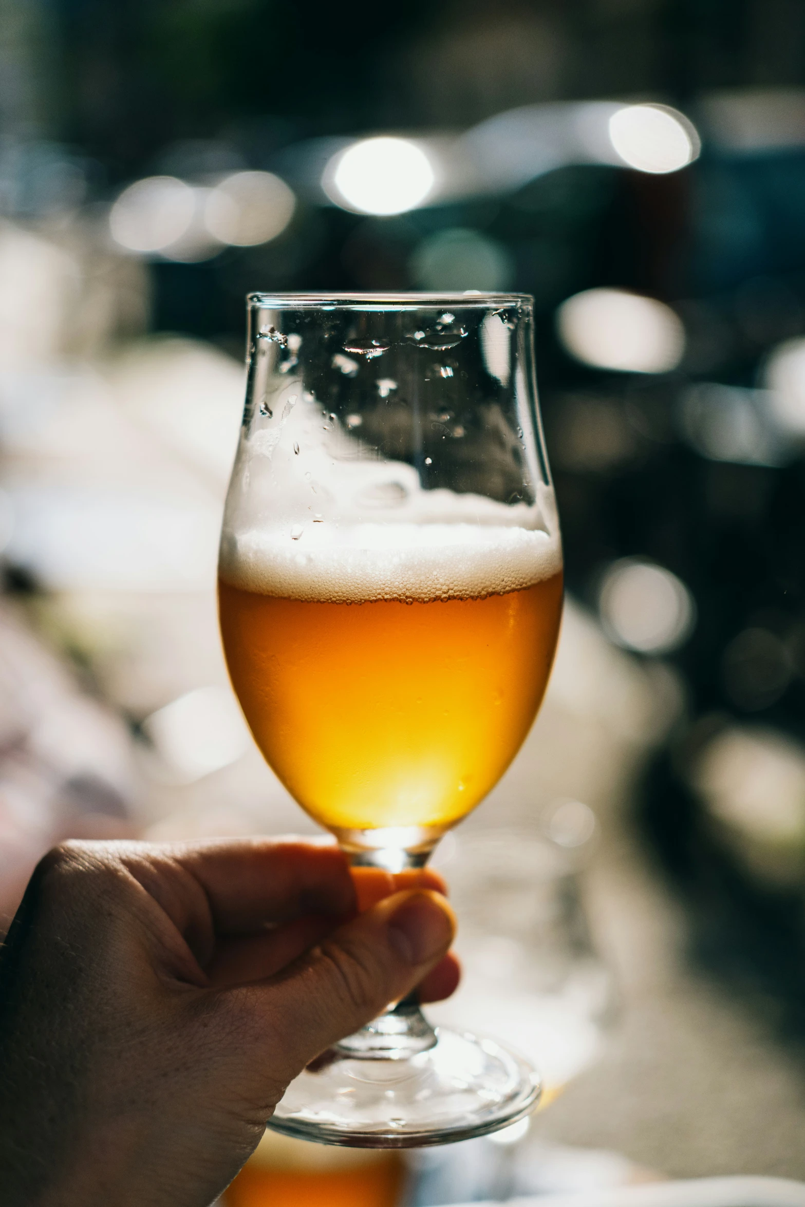 a person holds their hand next to a glass of beer
