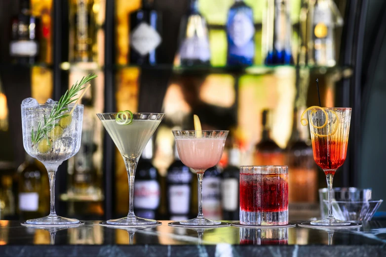 a group of glasses with different colored drinks