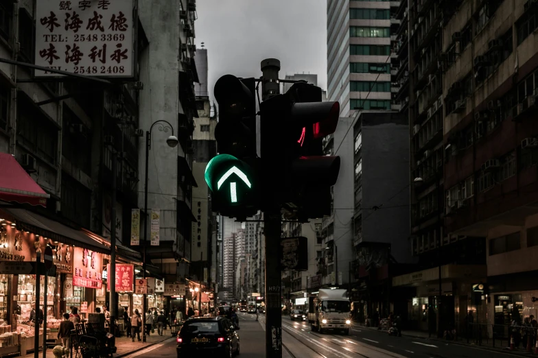 the neon traffic light shows green in a city street