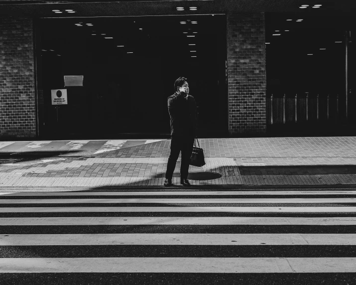 the man is waiting at an intersection to cross