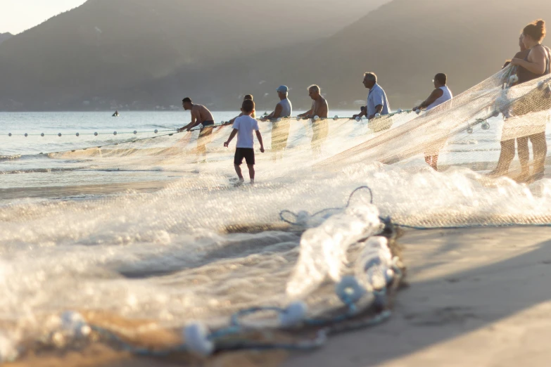 a group of people standing on top of a beach covered in nets