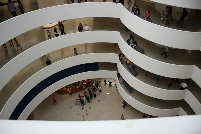 many people are walking around inside an office building