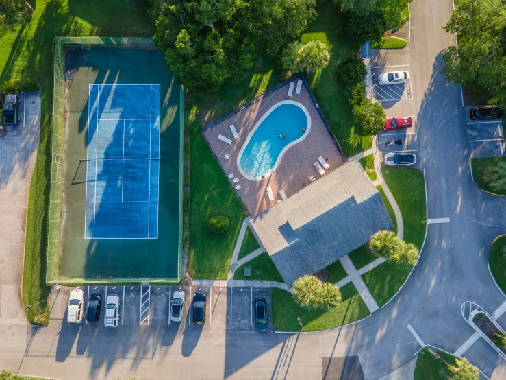 a po taken from above shows an overhead view of a tennis court and a parked car