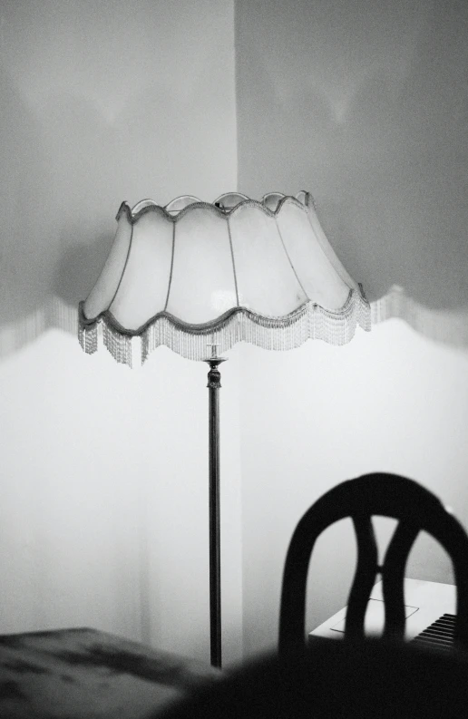 a table lamp and chair sit in a dark room