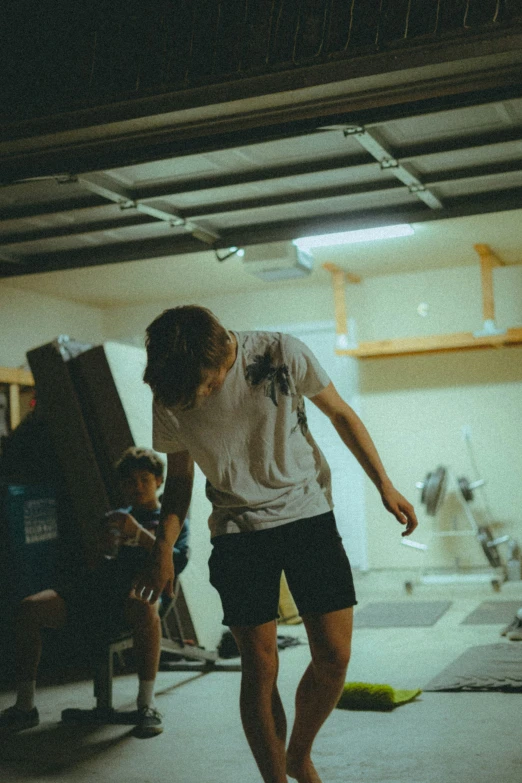 two people watch a man in the foreground skateboard