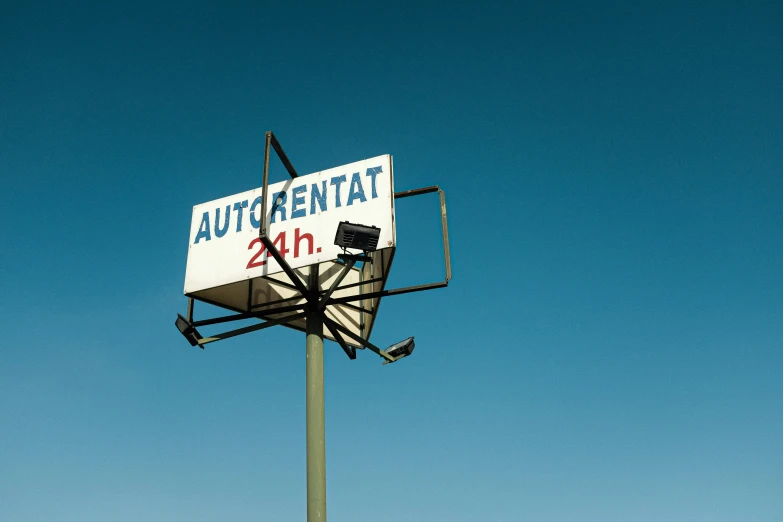 the auto repair sign is upside down against a blue sky