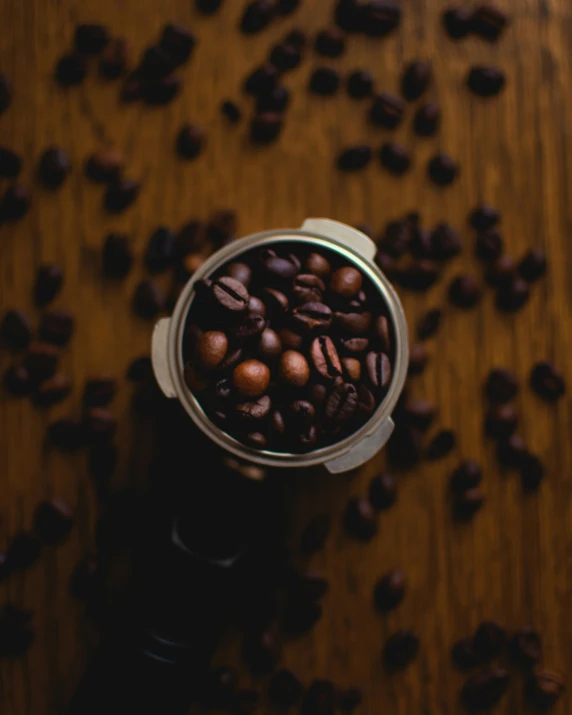 roasted coffee beans in a metal container on a wooden table