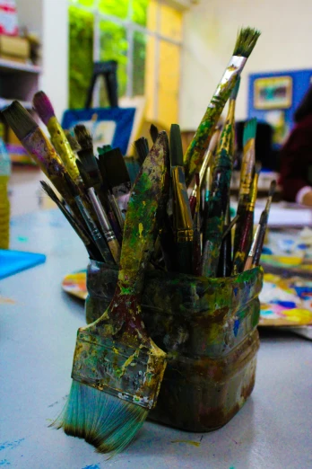 a close up of paint and brushes in a cup