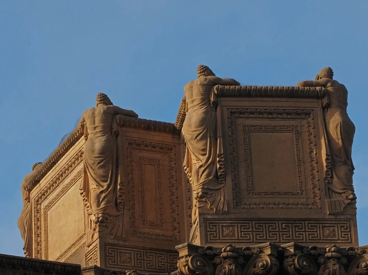 the top part of a building with sculptures on it