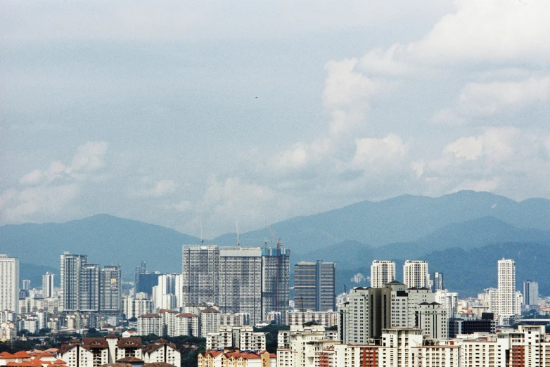 a city has tall buildings and mountains in the background