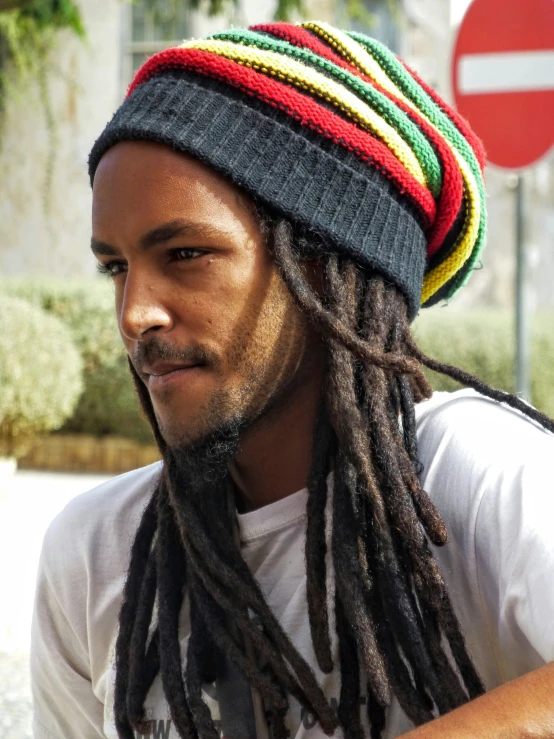 young man with dreadlocks looks to the side