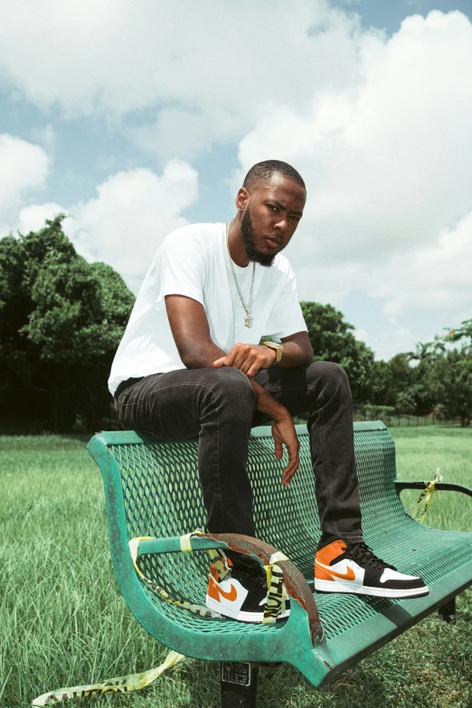 a person sitting on a green bench in the grass