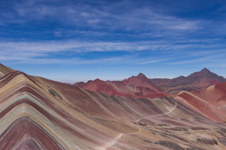 the aerial po of a hillside is mostly made out of rainbow mountains