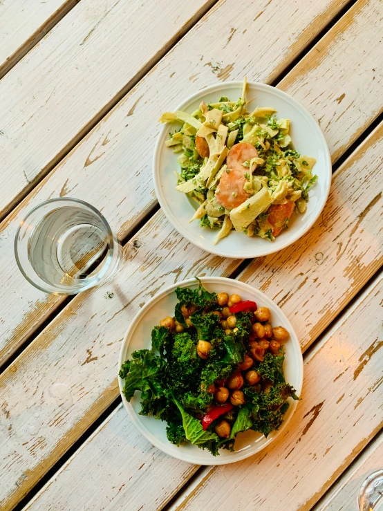 two white bowls and a glass sit on a table