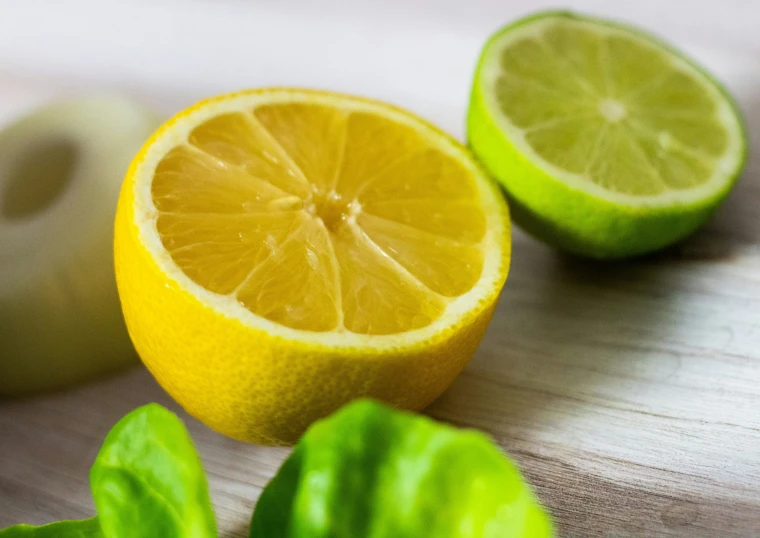 a sliced lime next to two green leaves